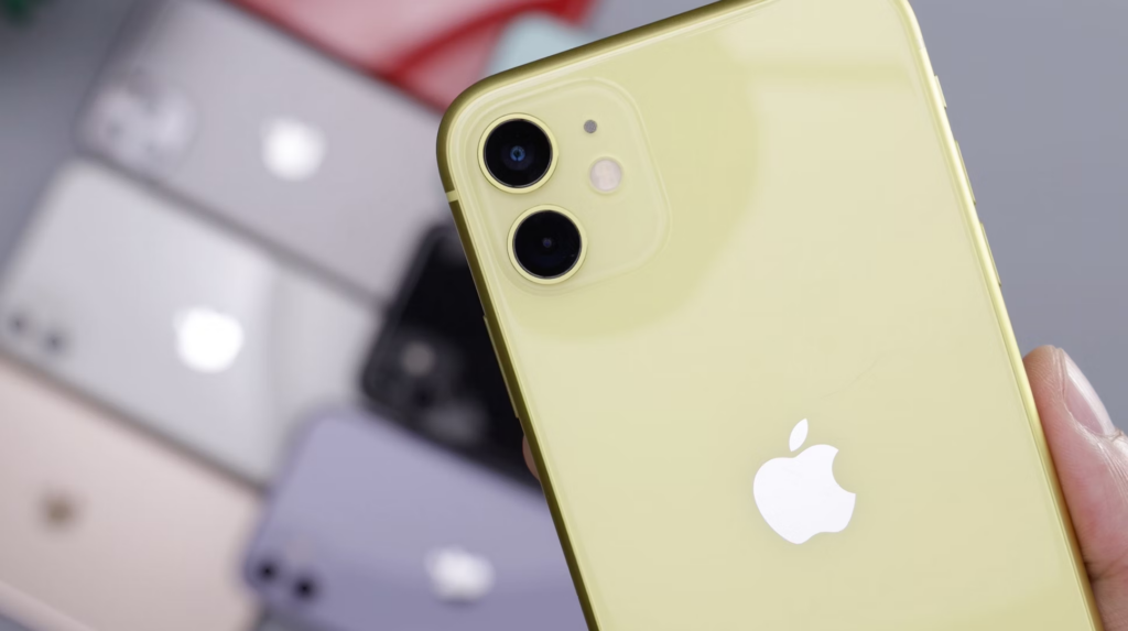Gold colored iPhone with several iPhones of different colors in the background. 